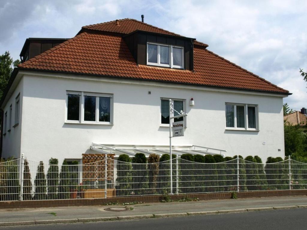 une maison blanche avec un toit rouge dans l'établissement Apartment Mengelberg, à Markkleeberg