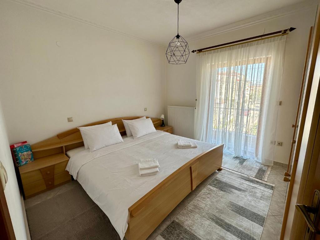 a bedroom with a large bed and a large window at Living Home Trikala in Tríkala