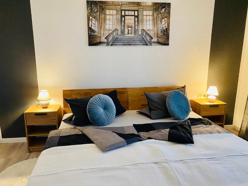 a bedroom with a large bed with blue pillows at Apartment- Metzingen in Metzingen