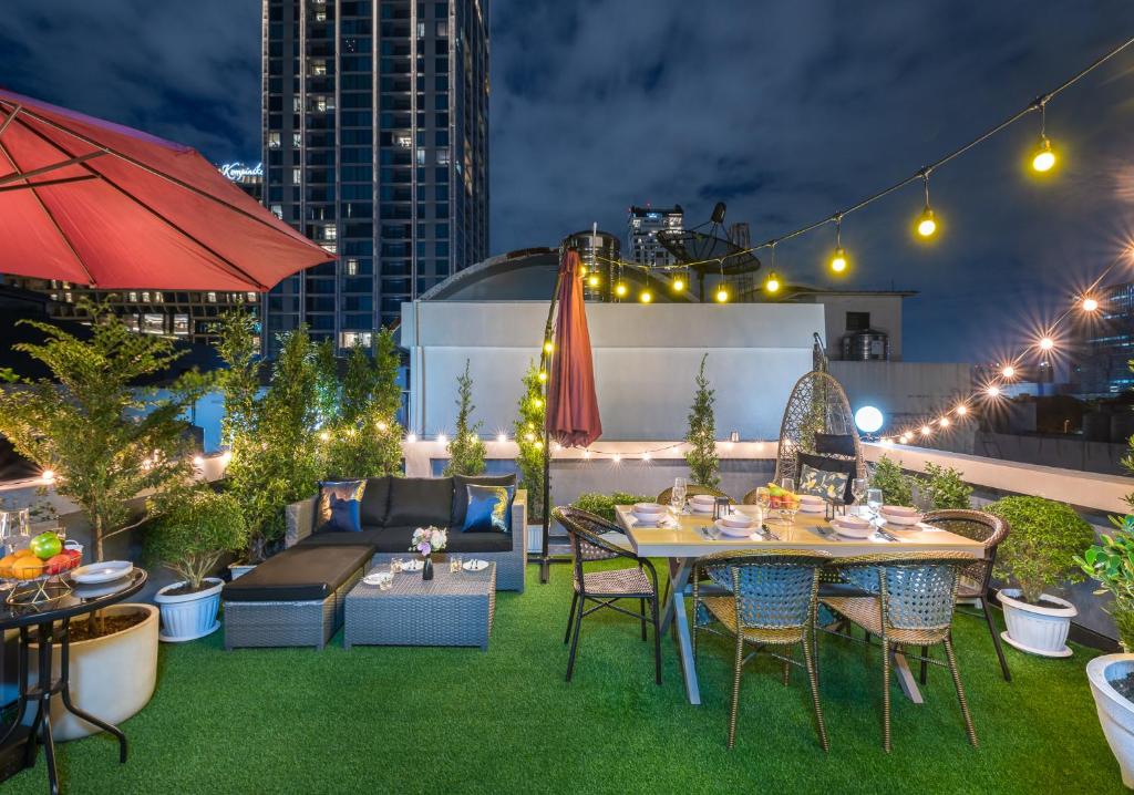 a rooftop patio with a table and chairs and lights at RoofTop Paradise, Newly Built Home. 5 mins walk to Lumphini Park. 900meters to ChidLomBTS in Bangkok