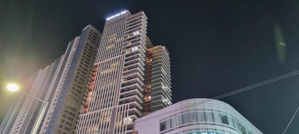 a tall building with lights on top of it at The solid residence - Elbon the stay by haeundae in Busan