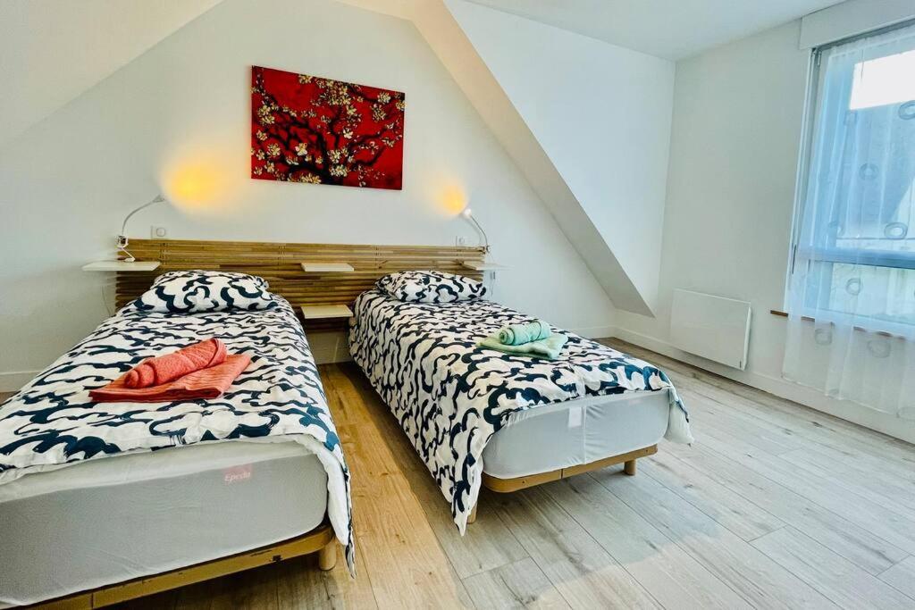 a bedroom with two beds and a painting on the wall at Pen ar Creac'h in Crozon