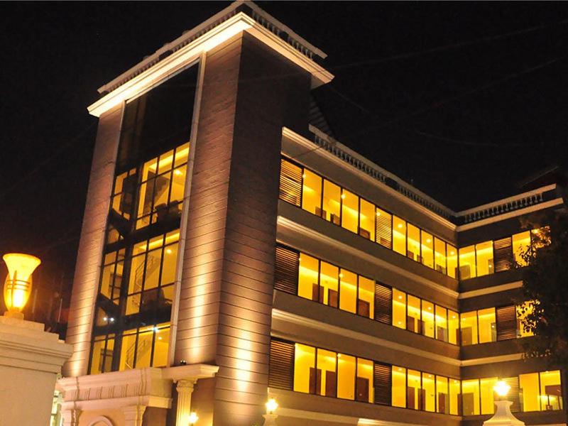 a large building with lit up windows at night at RKN Hotel in Puducherry