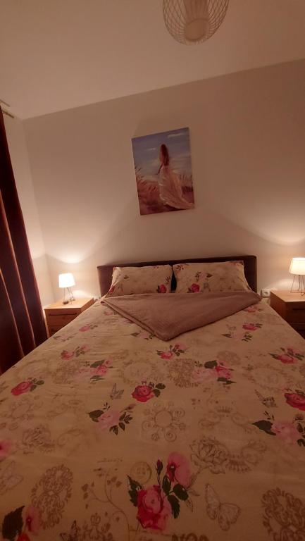 a bedroom with a bed with pink flowers on it at Apartman Centar Kozarska Dubica in Bosanska Dubica