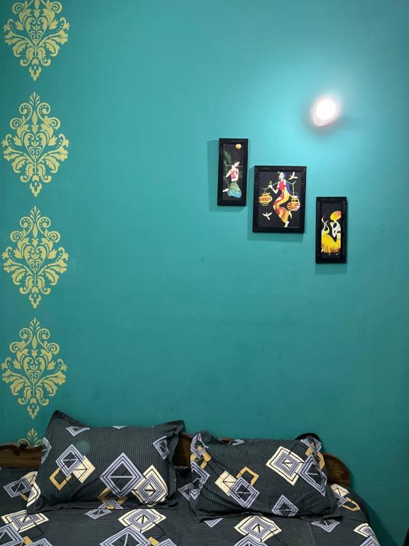 una camera da letto con quattro quadri su una parete blu di Anusha's Studio Room in Zirakpur Chandigarh a Zirakpur