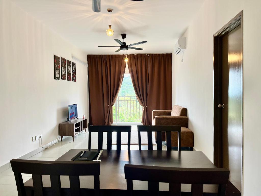 a living room with a dining room table and a ceiling fan at Omak Kito Homestay Melaka in Kampong Alor Gajah