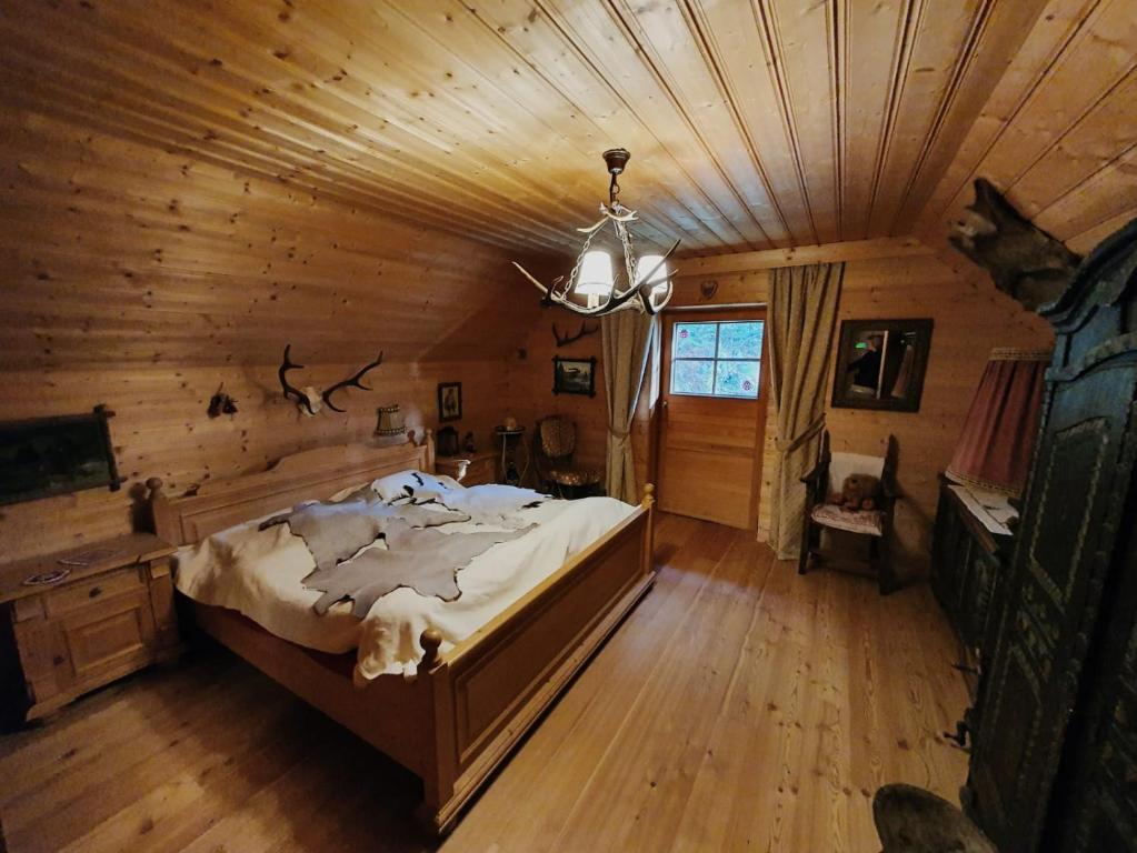 ein Schlafzimmer mit einem großen Bett in einem Blockhaus in der Unterkunft Chalet Hüttentraum by Globalimmoservice in Bad Kleinkirchheim