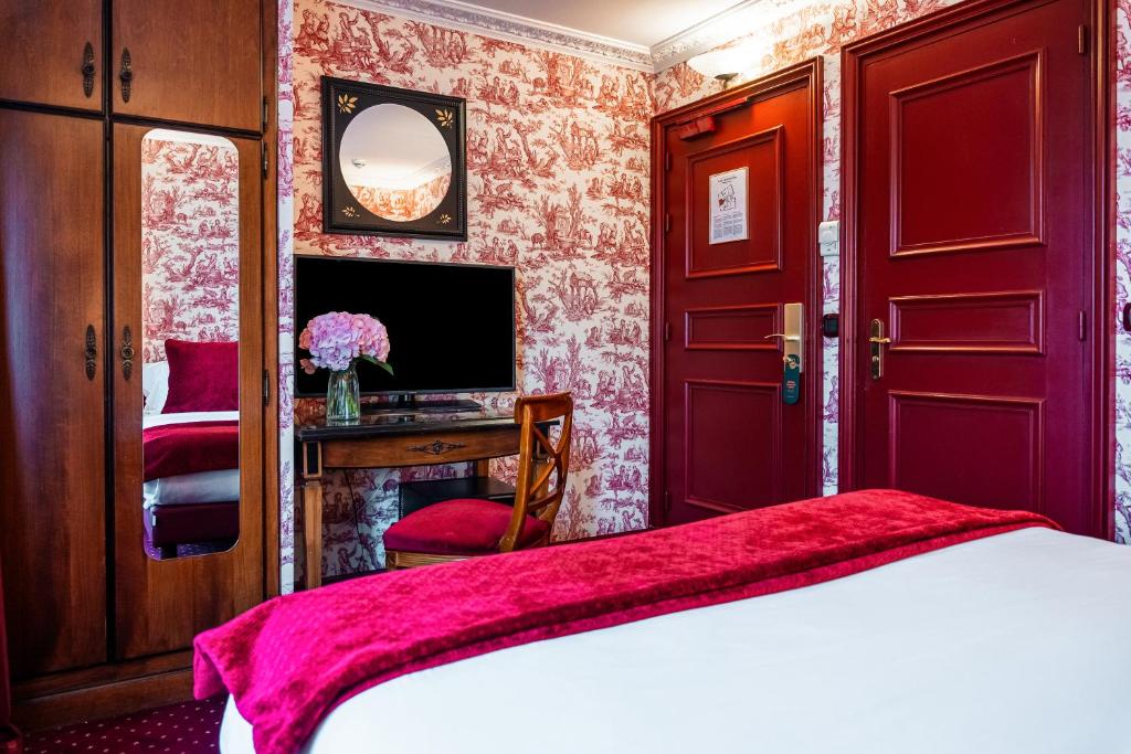 - une chambre avec un lit et un bureau avec une télévision dans l'établissement Maison Eugenie, à Paris