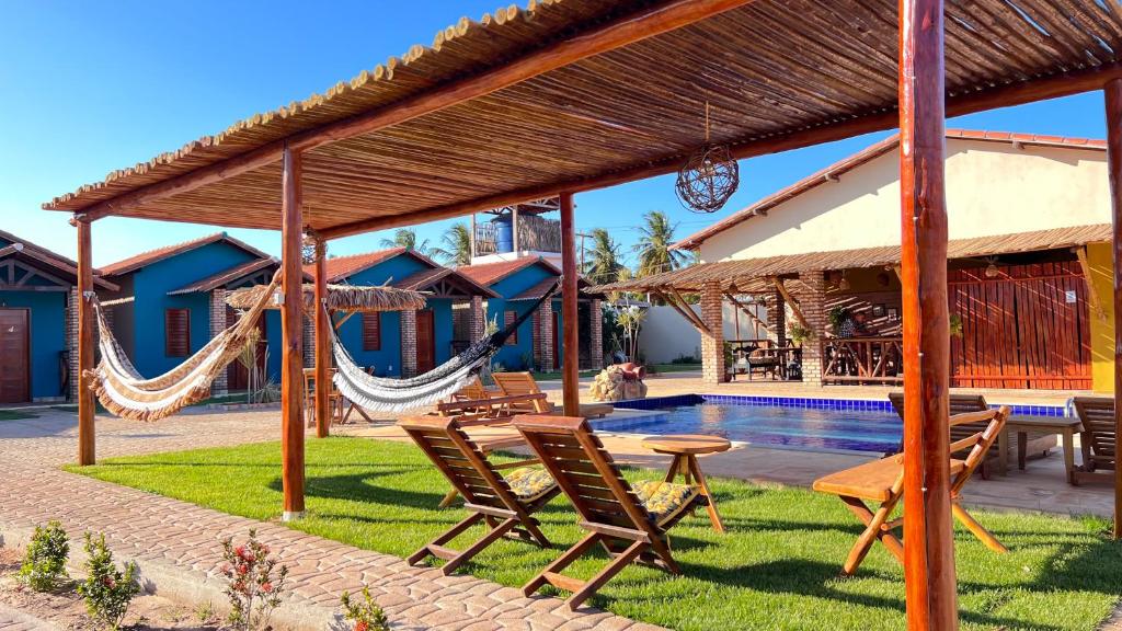 ein Resort mit einer Hängematte und einem Pool in der Unterkunft POUSADA DONNA MARIA in São Miguel do Gostoso