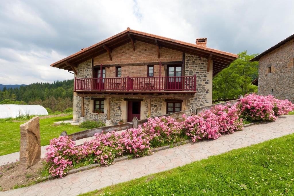 a house with pink flowers in front of it at Casa Rural Etxegorri in Orozko