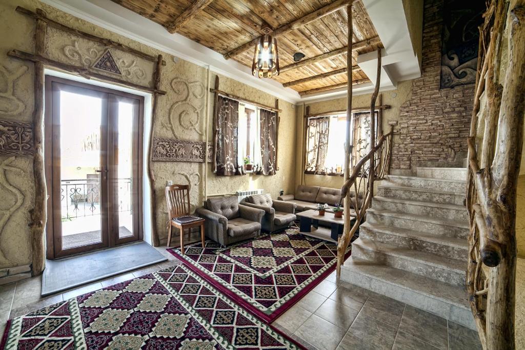 ein Wohnzimmer mit einem Sofa und einer Treppe in der Unterkunft Ethno boutique Hotel Osh in Osch