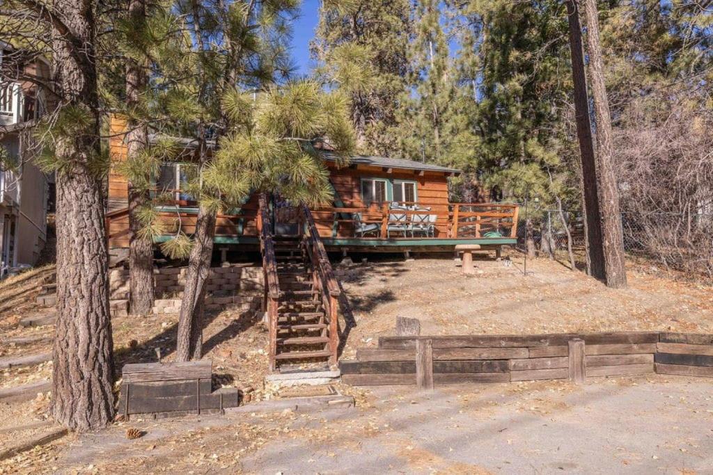 a cabin in the woods with stairs leading up to it at Donut Chalet with spa, BBQ grill, and firepit in Big Bear Lake