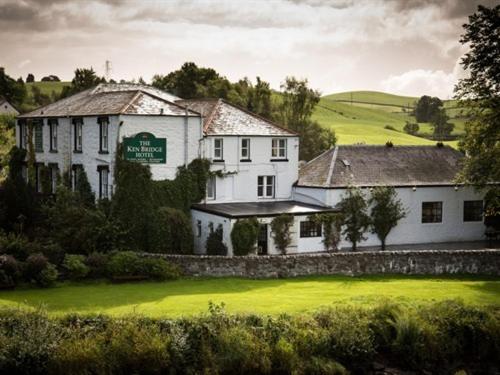 a large white building on a green field at The Ken Bridge Hotel in New Galloway