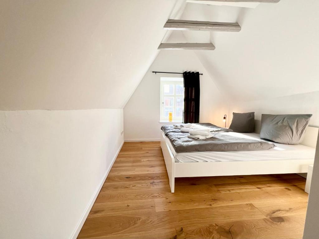 Schlafzimmer mit einem Bett und einem Fenster in der Unterkunft Historisches Kontorhaus, Zentral, 2Zi., Netflix! in Emden