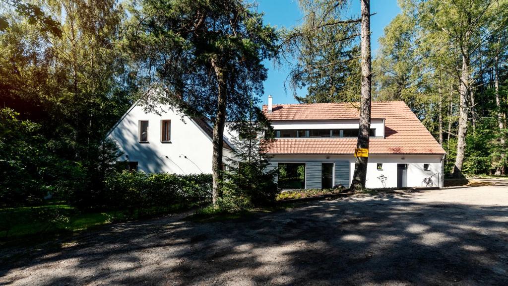 une maison blanche avec un toit rouge et une allée. dans l'établissement Penzion Blanko, à Nová Bystřice