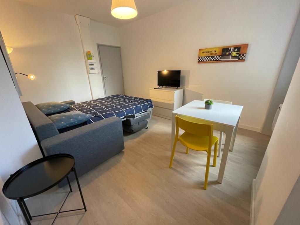 Habitación pequeña con cama, mesa y sillas en Le gambetta Hypercentre-Calme-wifi en Saint-Étienne