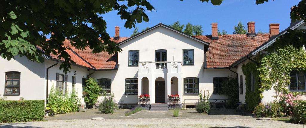 une maison blanche avec un toit rouge dans l'établissement Borregården Bed & Breakfast, à Borrby