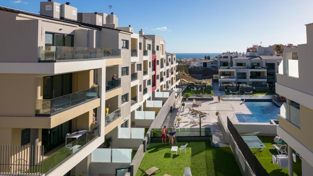 an apartment building with a courtyard and a swimming pool at Apartments Sydenbygg Arguineguin in Arguineguín