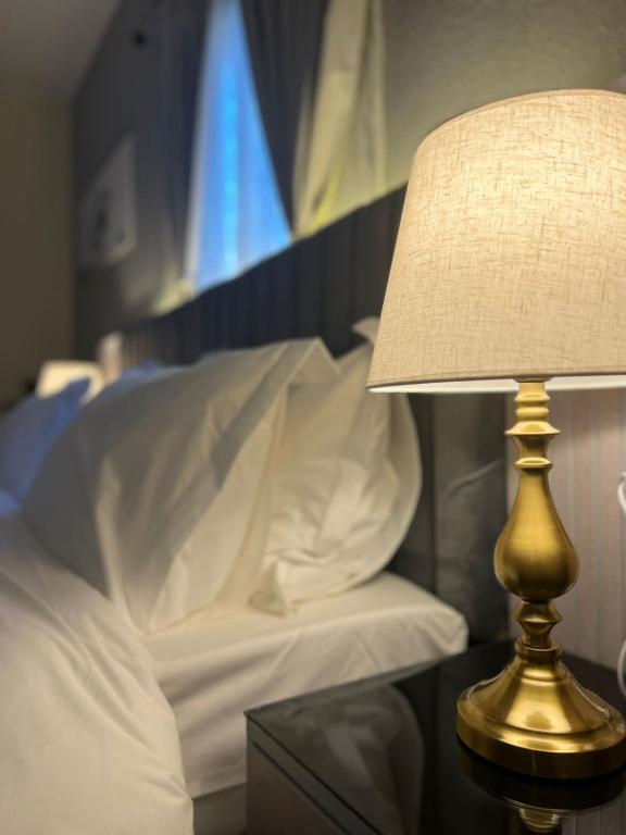 a lamp sitting on a table next to a bed at شقق ثمانين بارك1 in Khamis Mushayt
