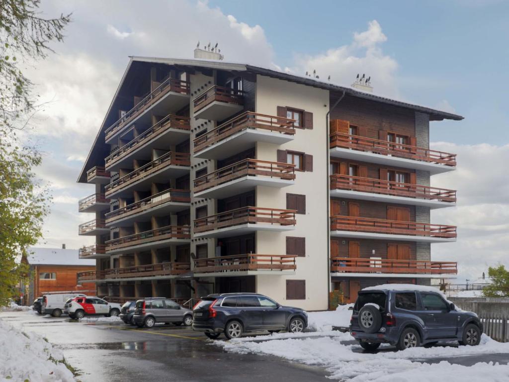 un edificio con coches estacionados en un estacionamiento en Apartment Quille du diable 19 by Interhome, en Nendaz