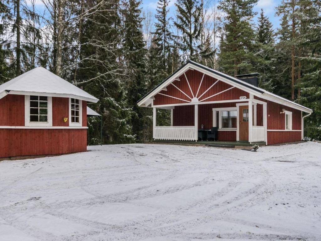 un petit bâtiment rouge avec une allée couverte de neige dans l'établissement Holiday Home Mäkimökki by Interhome, à Palikainen