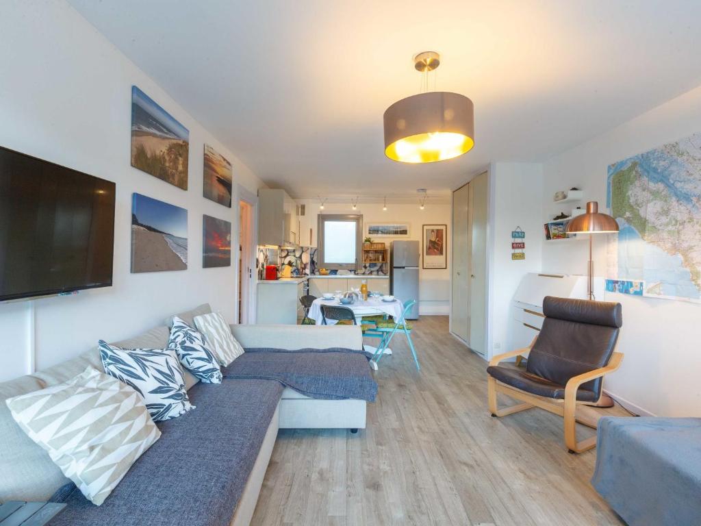 ein Wohnzimmer mit einem Sofa und einem Tisch in der Unterkunft Apartment Les Ecureuils-1 by Interhome in Les Mathes