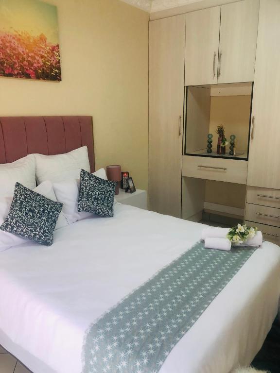 1 dormitorio con 1 cama blanca grande y 2 almohadas en Hlatse@ C-raneLodge, en Phalaborwa