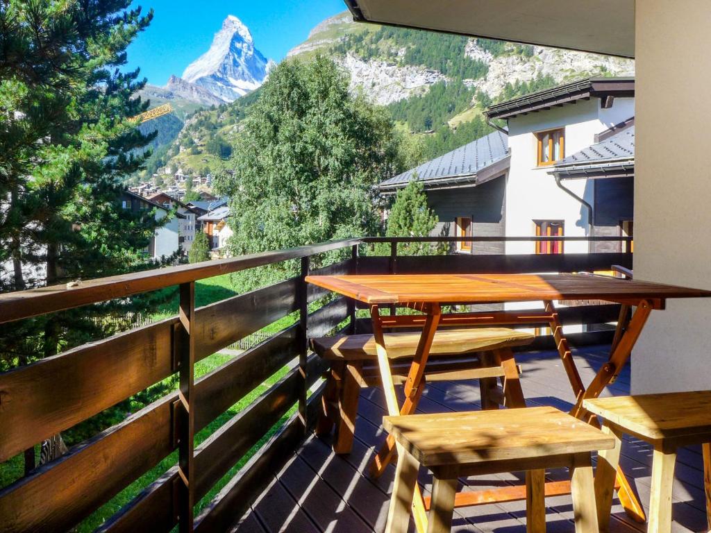a table and chairs on a balcony with a mountain at Apartment Papillon by Interhome in Zermatt
