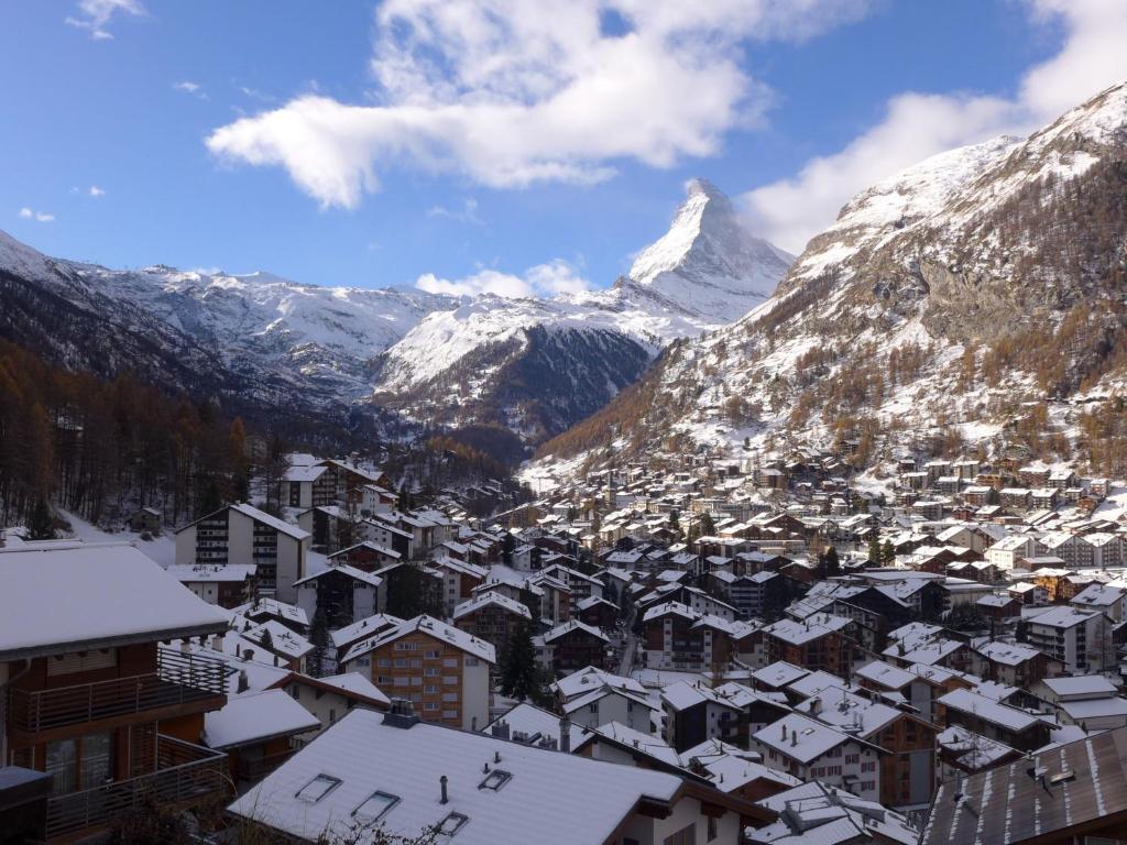 une ville avec des bâtiments recouverts de neige et une montagne dans l'établissement Chalet Uberer A1 by Interhome, à Zermatt