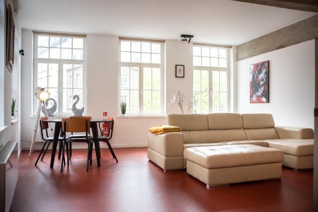 ein Wohnzimmer mit einem Sofa und einem Tisch in der Unterkunft The Industria - Stylish in Historical Center in Antwerpen