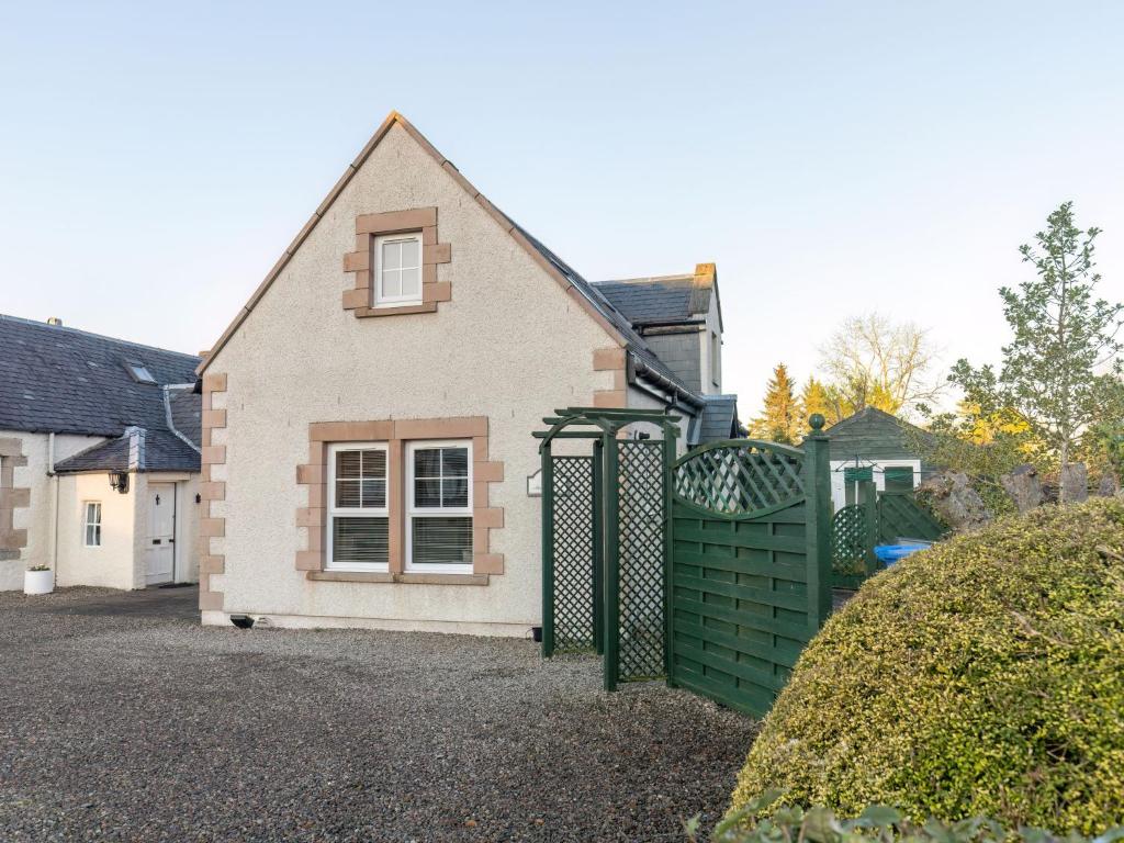 a house with a green gate in front of it at Holiday Home Lodge Road-1 by Interhome in Inverness