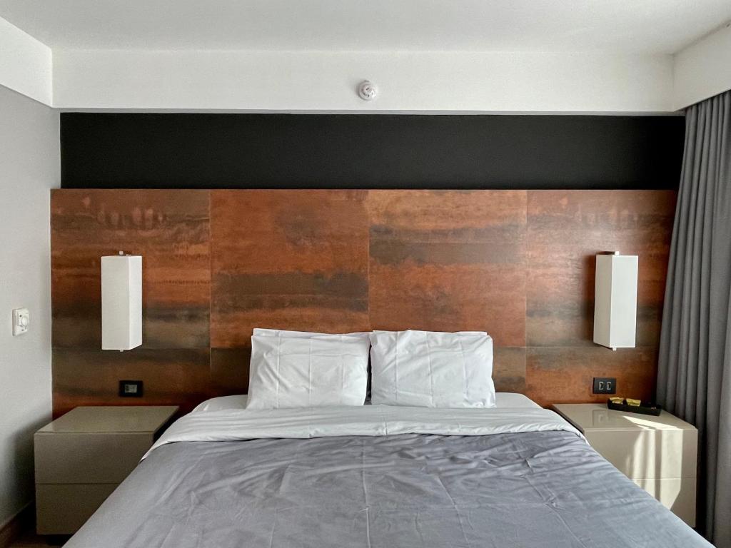 een slaapkamer met een bed met een houten hoofdeinde bij Flat particular incrível dentro do hotel M Ibirapuera em Moema in Sao Paulo