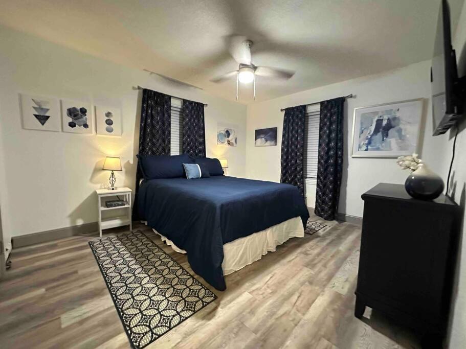 a bedroom with a blue bed and a night stand at Comfy College Cottage Near Stadium & Campus in Tallahassee