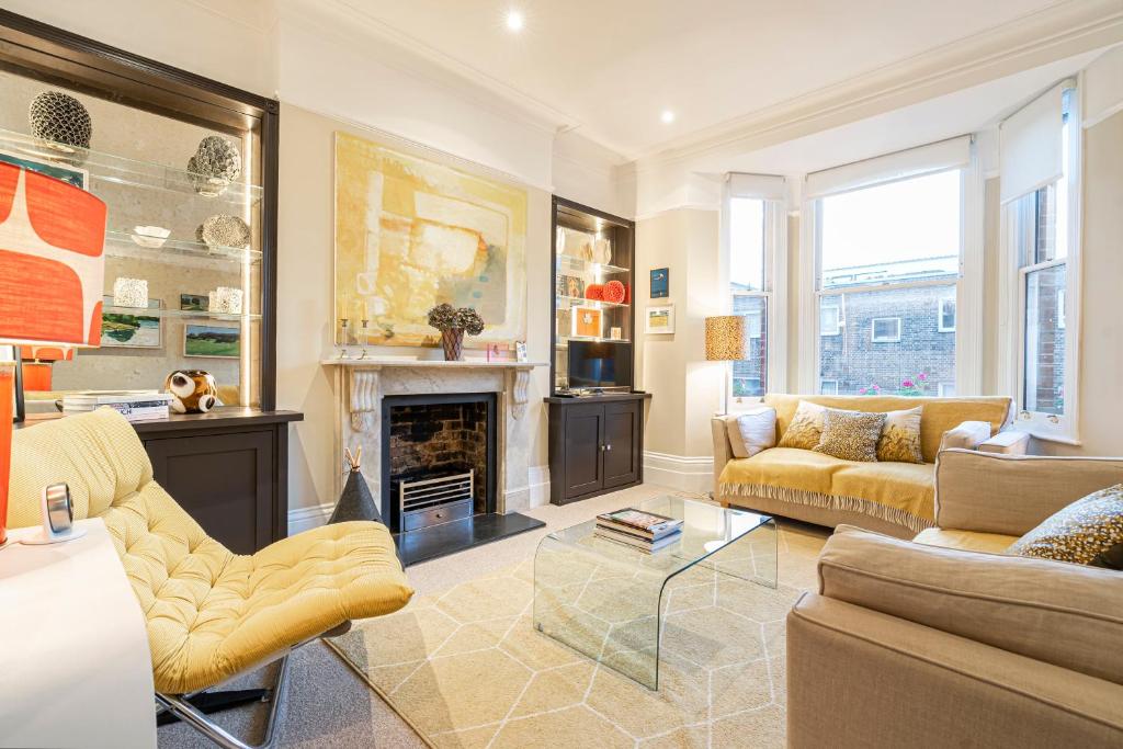 salon z kanapą i kominkiem w obiekcie JOIVY Elegant 1 bed flat in Chelsea w Londynie