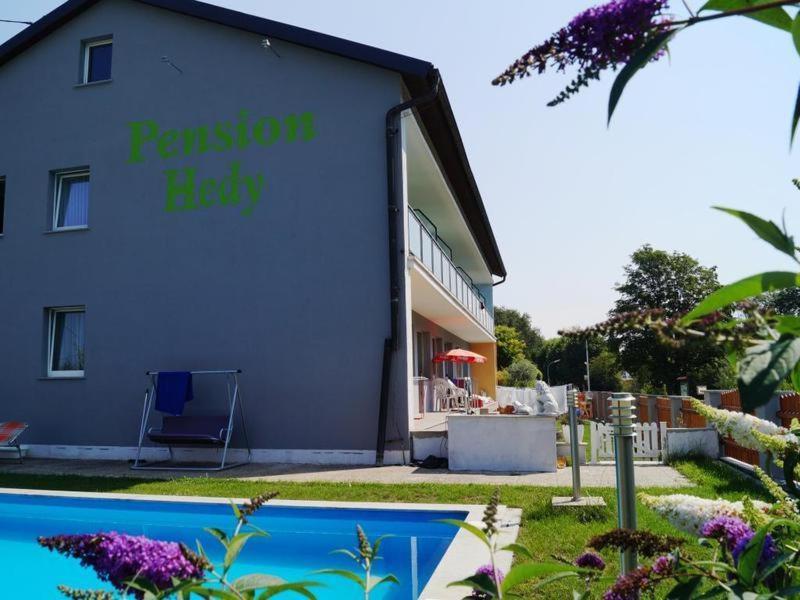 a building with a swimming pool in front of a house at Pension Hedy in Bad Schallerbach