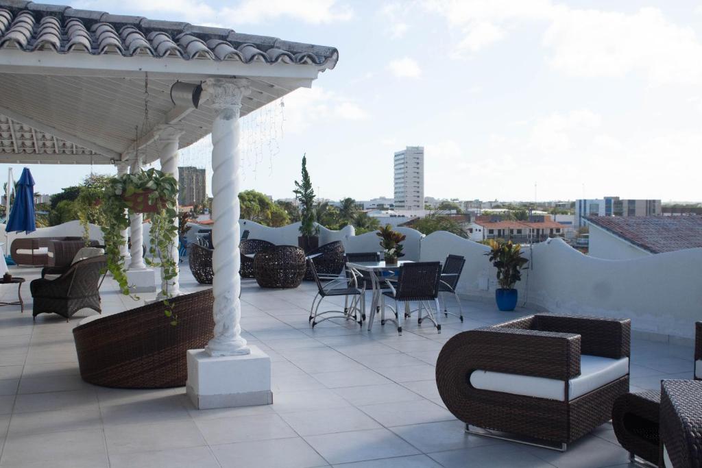 eine Terrasse mit einem Tisch und Stühlen auf dem Dach in der Unterkunft New Casablanca Praia Hotel in Paulista