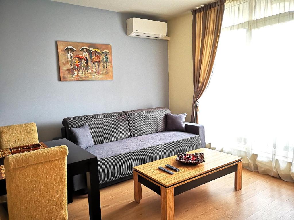 a living room with a couch and a table at Mladost Apartments Sofia in Sofia