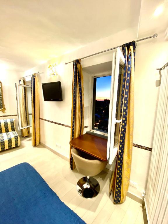 a bedroom with a window with a toilet and a tv at The Manarola Main Plaza in Manarola