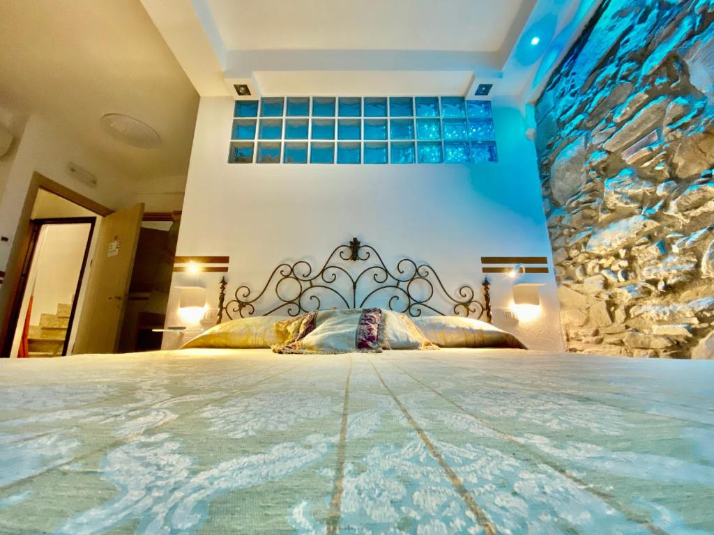 a bedroom with a large bed with a stone wall at The Manarola Main Plaza in Manarola
