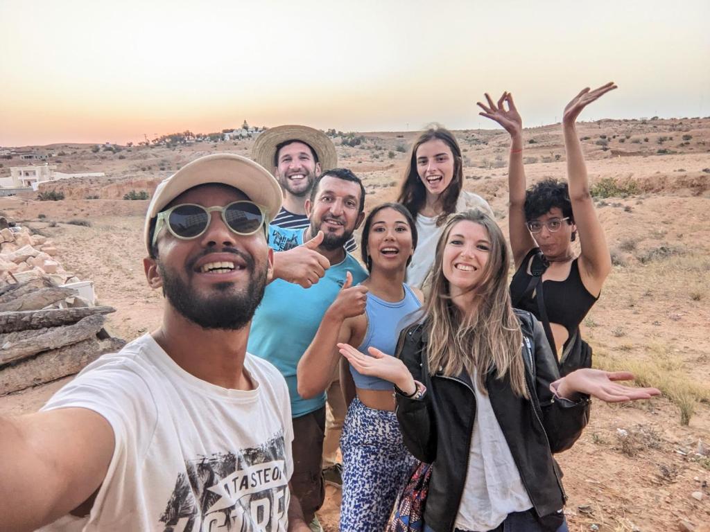um grupo de pessoas posando para uma foto no deserto em Wostel Djerba em Erriadh