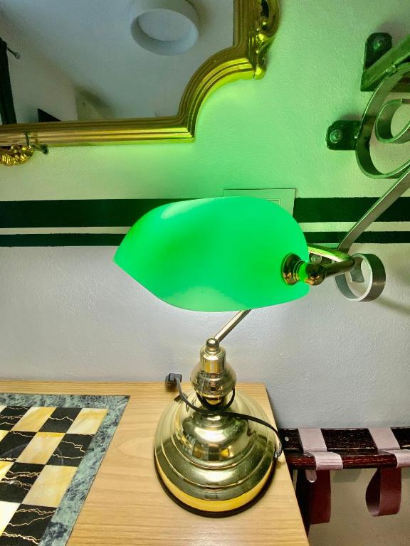 a green lamp sitting on top of a table at The Manarola Main Plaza in Manarola