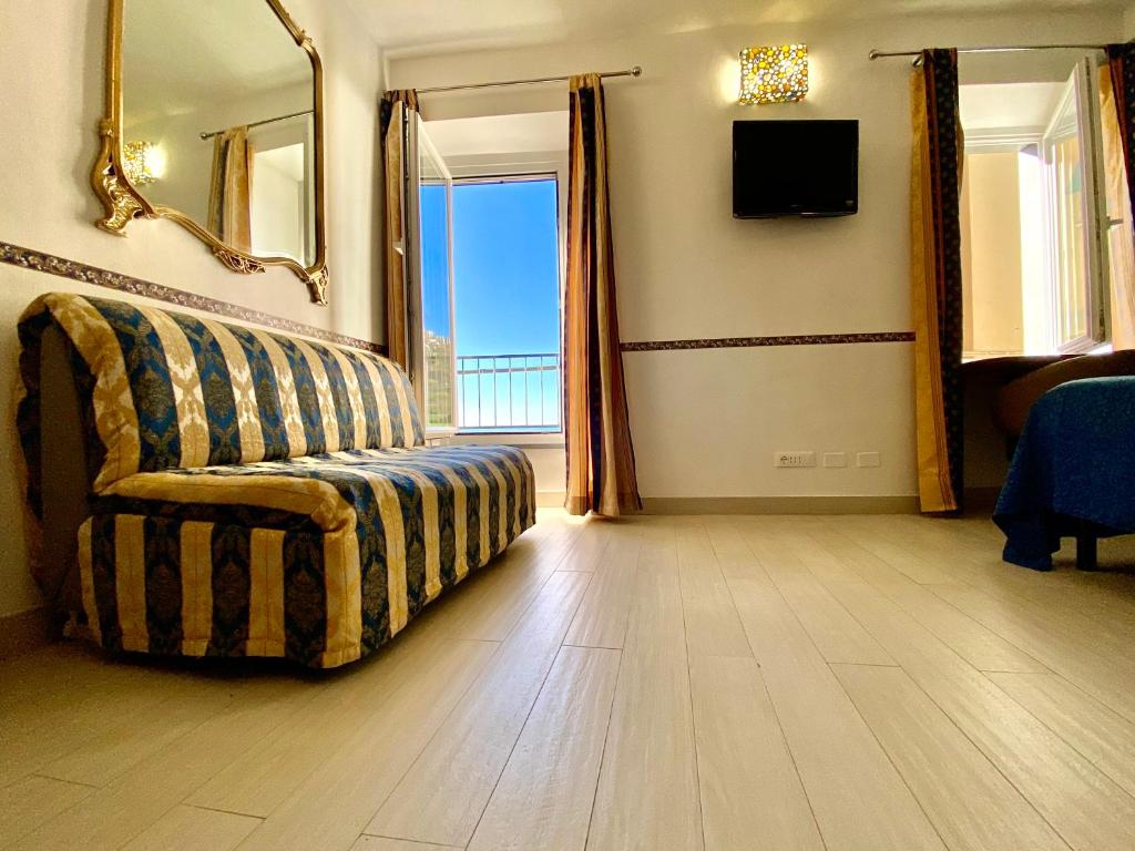 a living room with a couch and a large window at The Manarola Main Plaza in Manarola