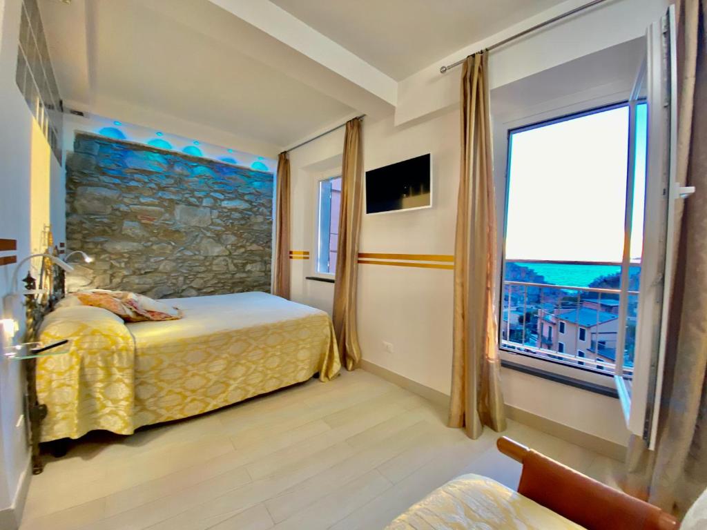 a hotel room with a bed and a large window at The Manarola Main Plaza in Manarola