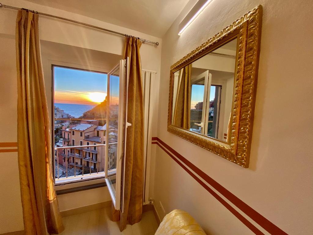 a room with a mirror and a window with a view at The Manarola Main Plaza in Manarola
