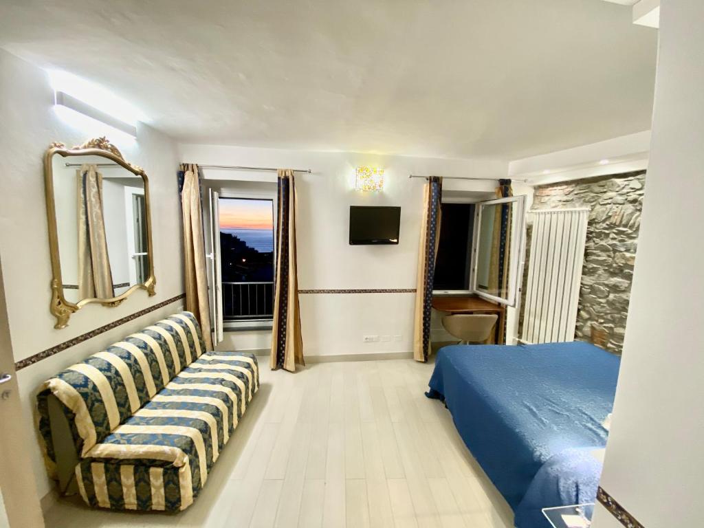 a bedroom with a blue bed and a couch at The Manarola Main Plaza in Manarola