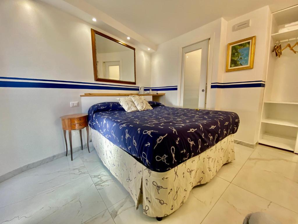 a bedroom with a bed with blue sheets and a mirror at The Manarola Main Plaza in Manarola
