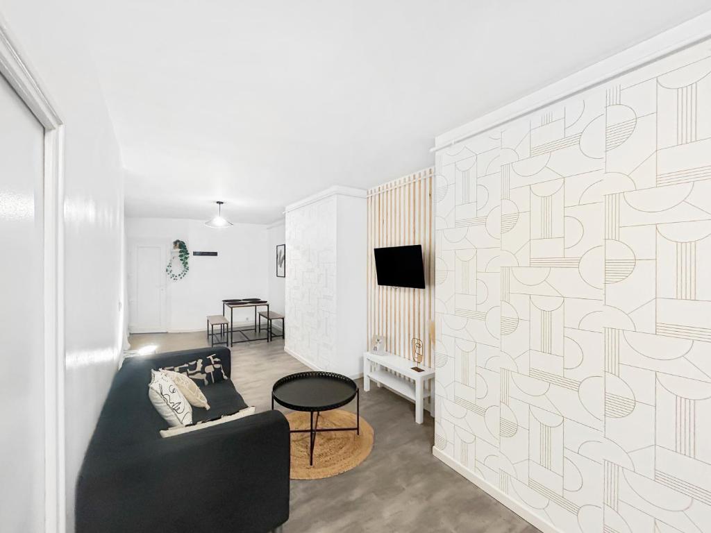 un salon avec un canapé et une télévision dans l'établissement L'Empreinte Stéphanoise, à Saint-Étienne