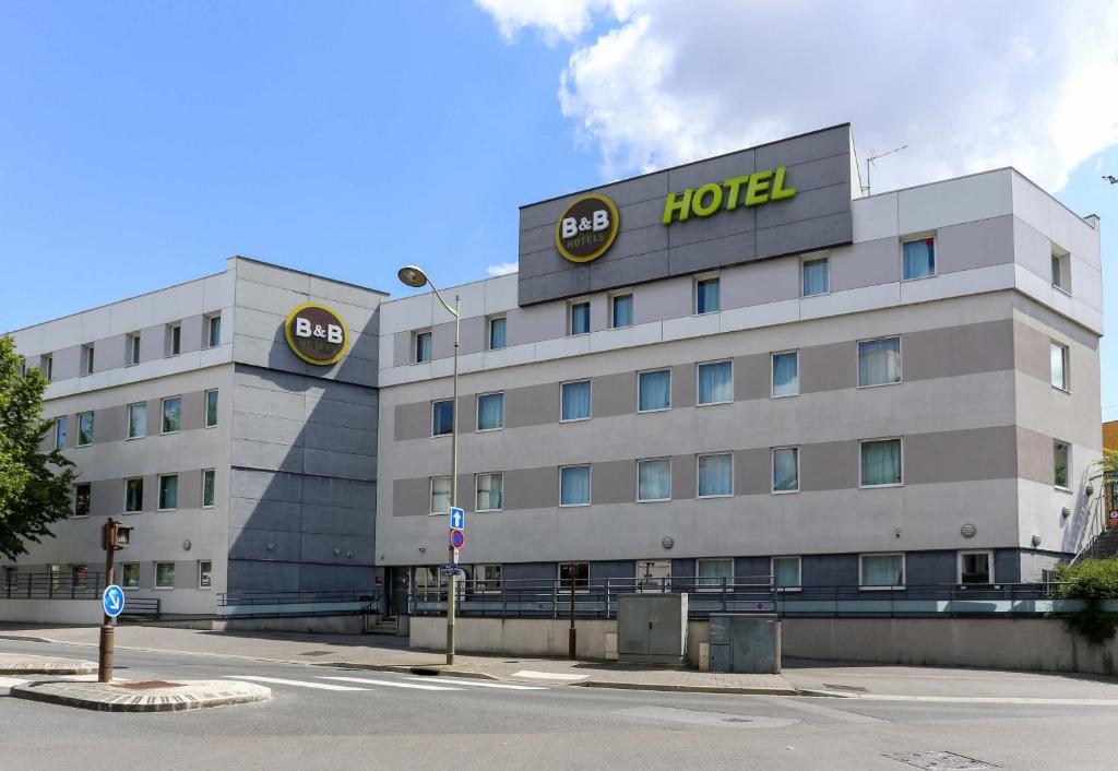 un bâtiment d'hôtel avec un panneau d'hôtel dans l'établissement B&B HOTEL Reims Centre Gare, à Reims