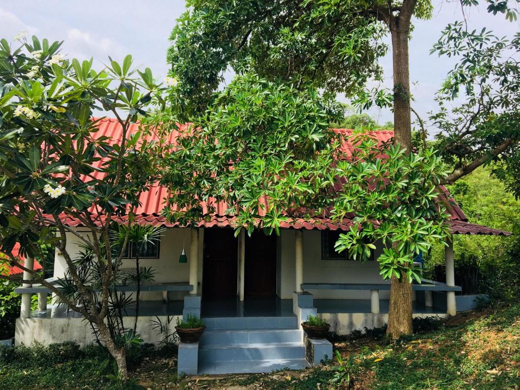 una pequeña casa con techo rojo en LungYod guesthouse, en Ban Tha Ling Lom