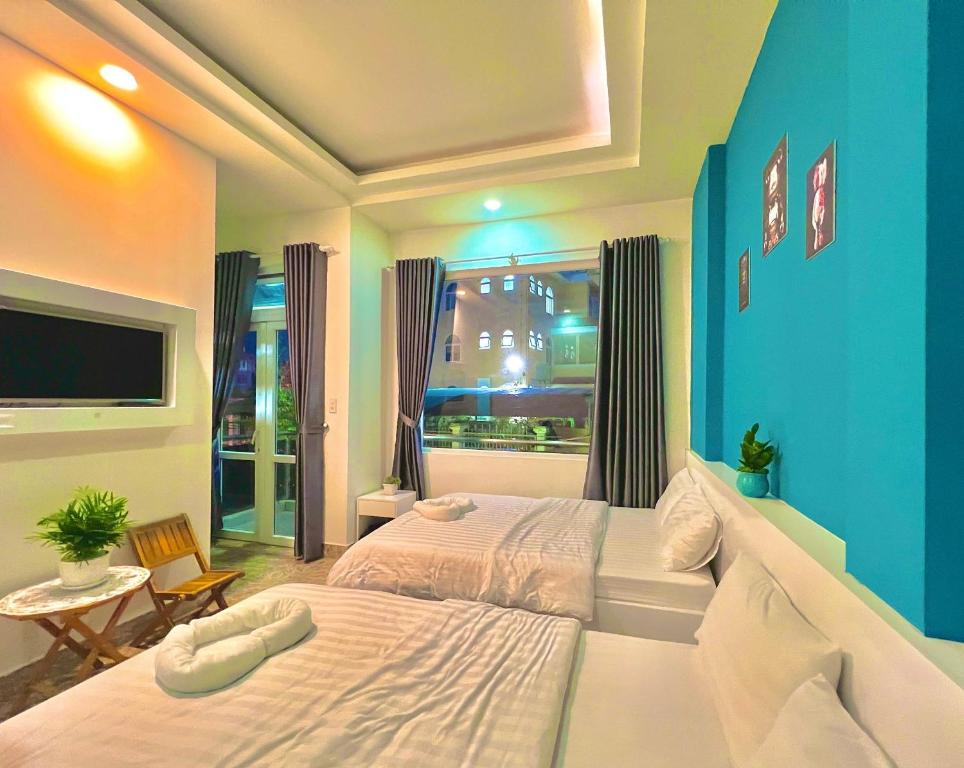 1 dormitorio con 1 cama grande y pared azul en Gia Khang, en Da Lat